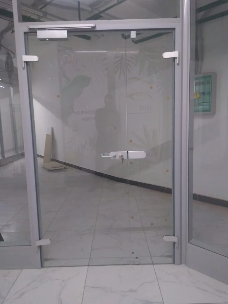 Стеклянная дверь в торговом центре: фурнитура ASSA ABLOY, профиль 95×35 RAL 9006